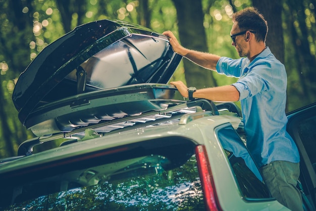 Photo men opening car roof rack in forest
