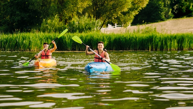 Foto uomini che remano in kayak sull'acqua increspata