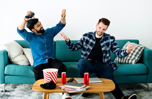 Men playing video game on sofa