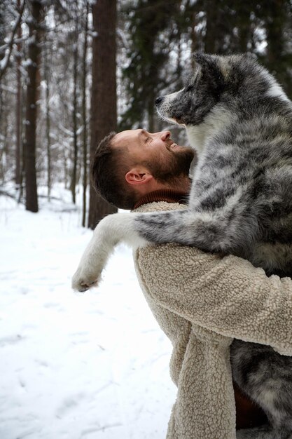 Men playing with siberian husky in winter forest and park animals and ecology