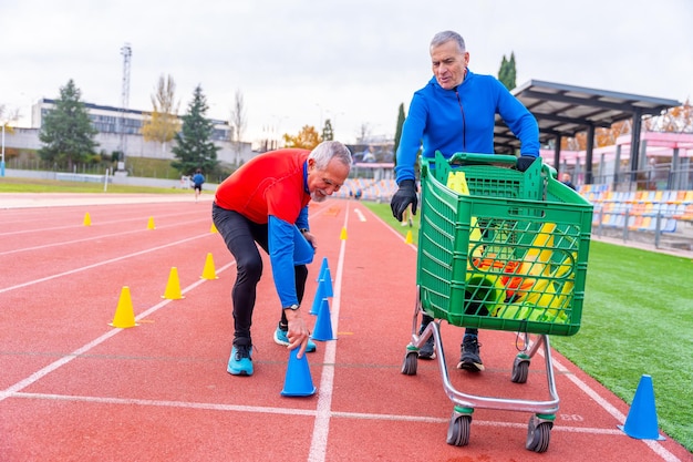 ランニング・トラックでトレーニングするためのコーンを準備する男性