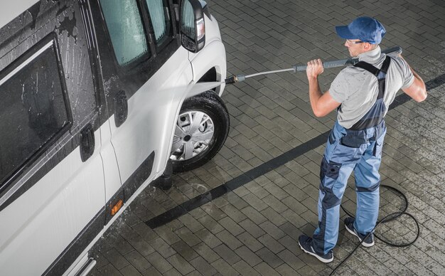 Men pressure washing his rv camper van