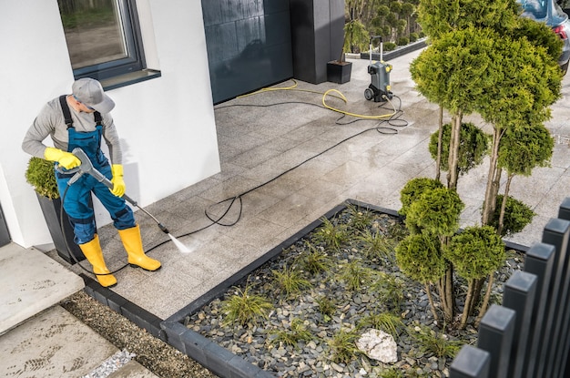 Men Pressure Washing House Surrounding Concrete Elements