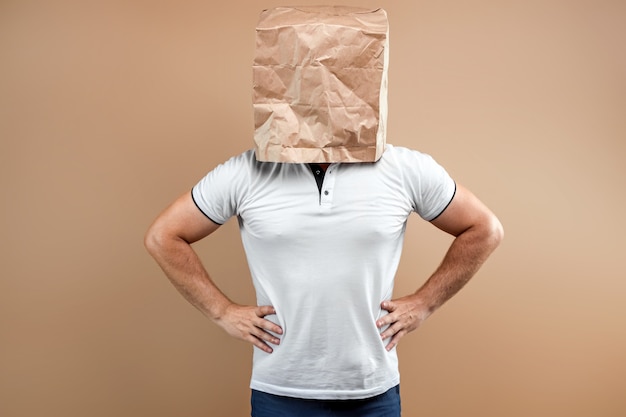 Men put a paper bag on their heads, keep their hands on their belts, businesslike, serious. Isolate on yellow background, images are easy to crop for use anywhere, copy space.