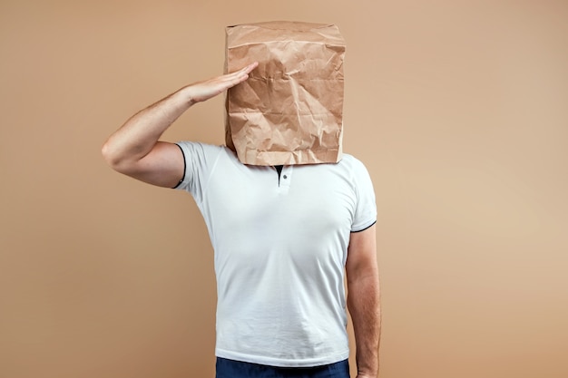 Men put a paper bag on their heads, salutes. Isolated on yellow background, images are easy to crop for use anywhere, copy space.