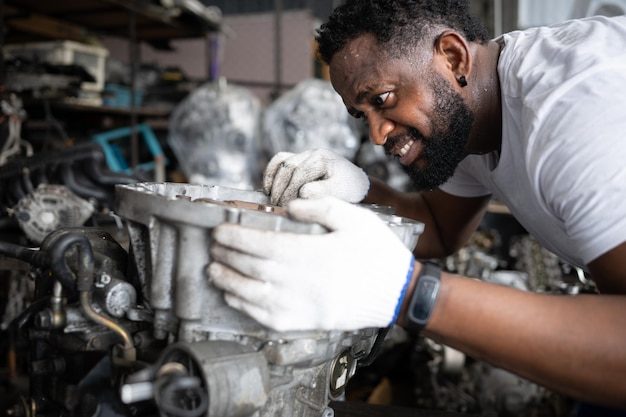 自動車修理所で車のエンジンを修理する男性 選択的な焦点