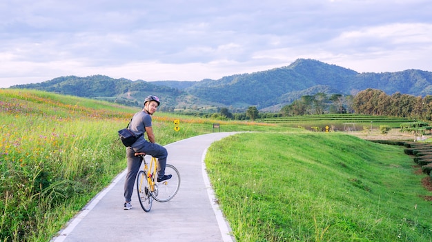 Singha公園チェンライ、タイの湖の近くに自転車に乗っている男性。