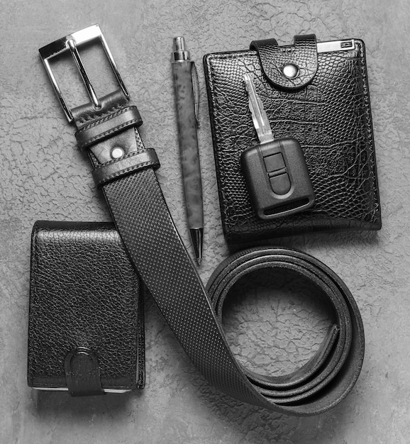 Men's accessories on a dark concrete surface