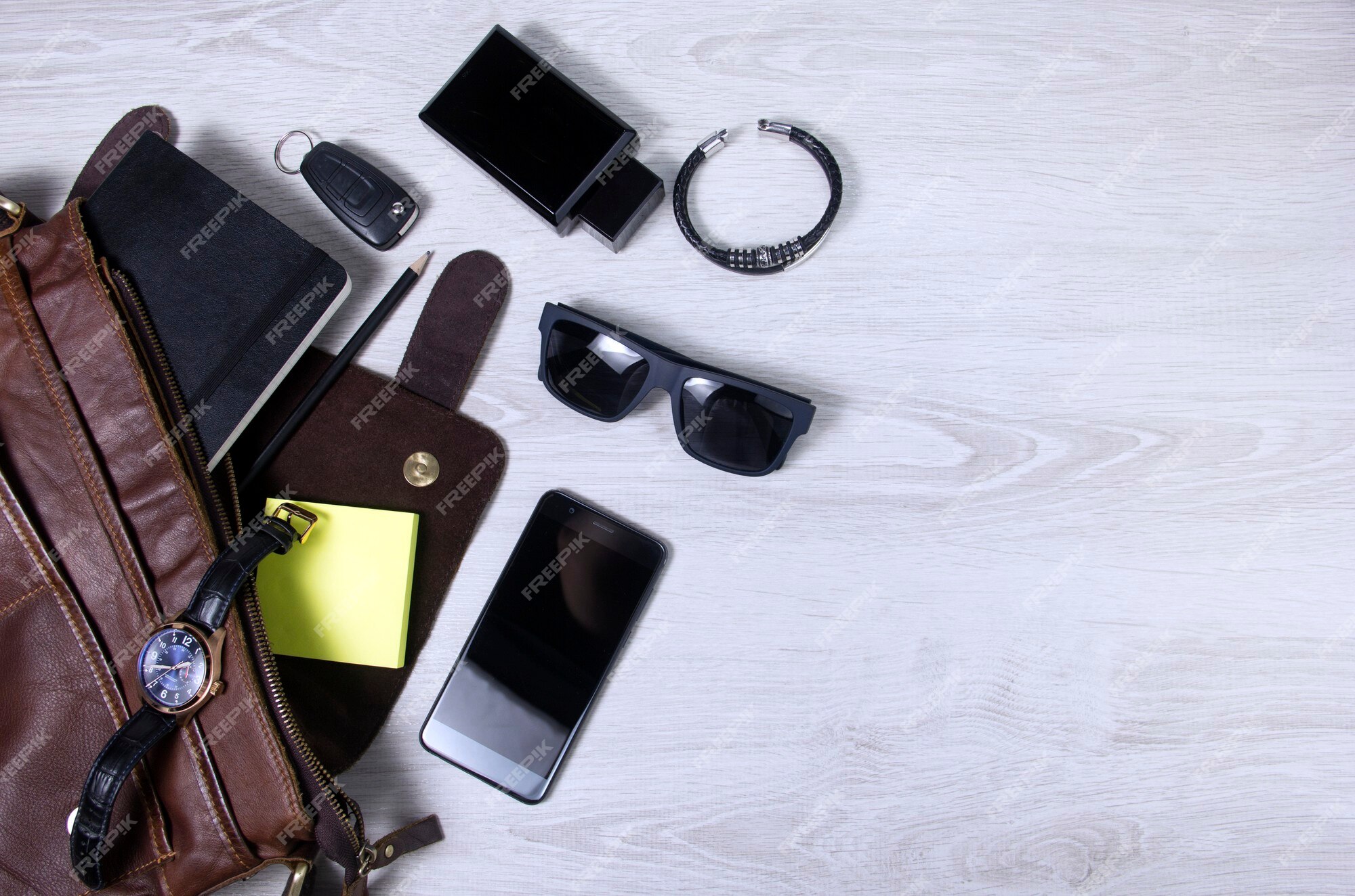 Mens Accessories With Dark Brown Leather Bags On Wooden Table Over