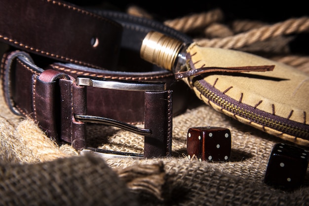 Men's accessories with brown leather belt, sunglasses, watch, smoking pipe and bottle with perfume 