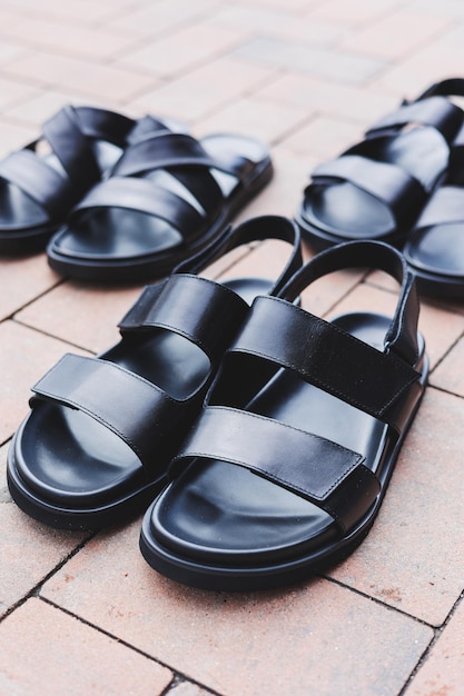 写真 男性用の黒い革のサンダルは、孤立した背景に立つ男性用の靴の夏のコレクション