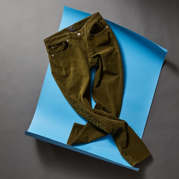 Men's casual outfits with men clothing on blue paper and concrete black wall