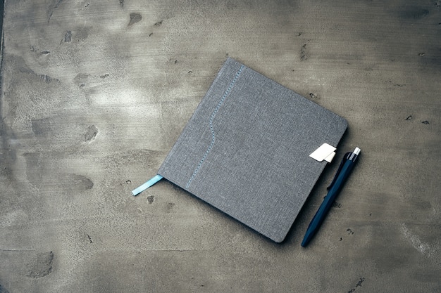 Men's diary and pen on dark grey background close up