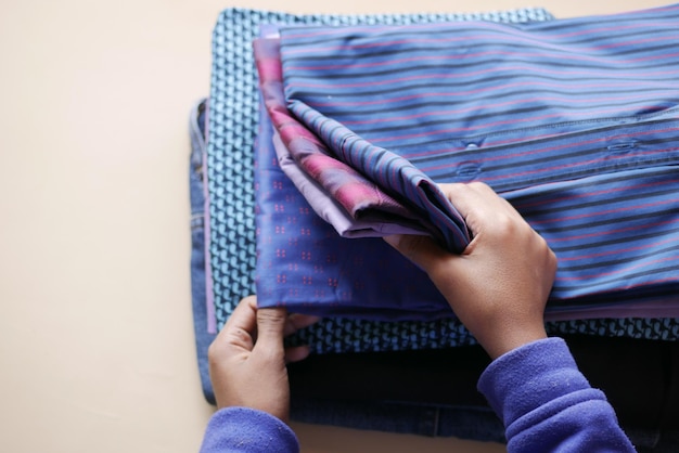 men's hand counting clothes on table .