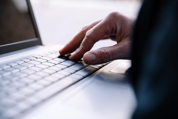 Men's hand typing on a laptop keyboard Selective focus