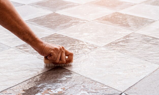 Men's hands are used to convert polishing cleaning on the tile floor.