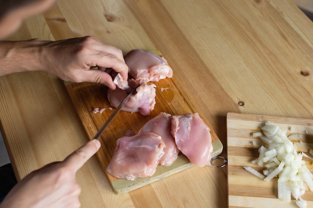 Men's hands butcher poultry meat