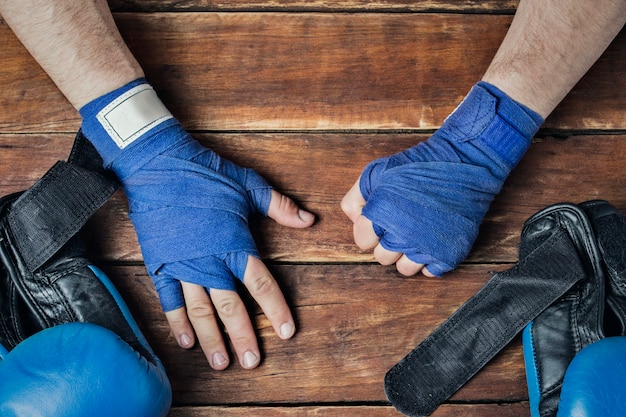Руки людей во время записи на пленку перед боксерским поединком на деревянной предпосылке.