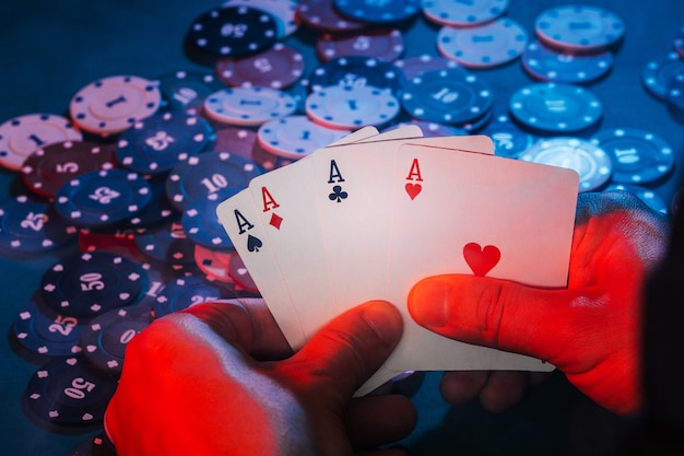 Photo men's hands hold cards , a set of aces on the background of playing chips