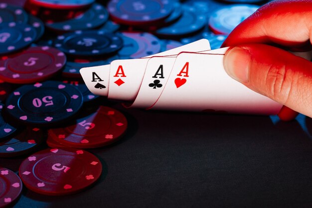 Men's hands hold cards , a set of aces on the  of playing chips