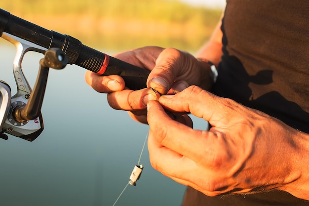 Foto le mani degli uomini tengono il gancio e infilano la pesca del verme