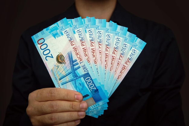 Men's hands hold a pack of new 2000 ruble bills