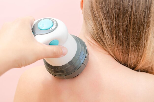 Photo men's hands massage females neck and shoulder by massager