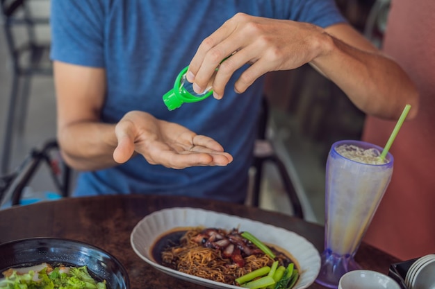 Men's hands using wash hand sanitizer gel pump dispenser.