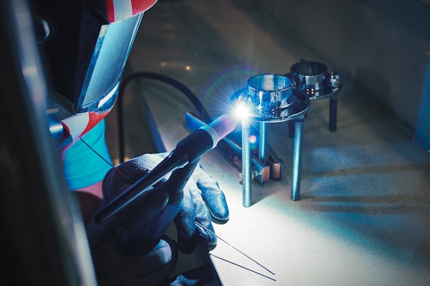 Men's hands with argon welding machine.