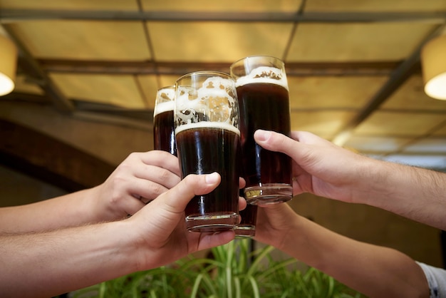 Men's hands with glasses of beer.