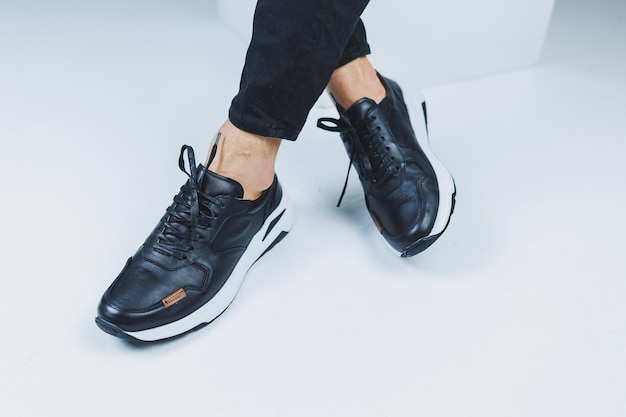 Men's legs in casual shoes of black color made of genuine leather men on shoes in black sneakers High quality photo