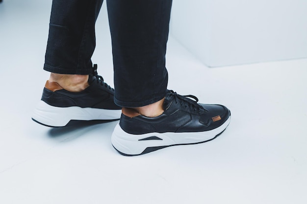 Men's legs in casual shoes of black color made of genuine
leather men on shoes in black sneakers high quality photo