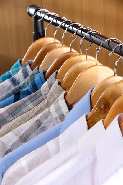 Men's shirts on hangers in wardrobe