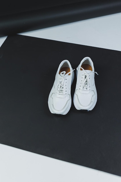 Men's white leather sneakers on a black background Men's casual shoes