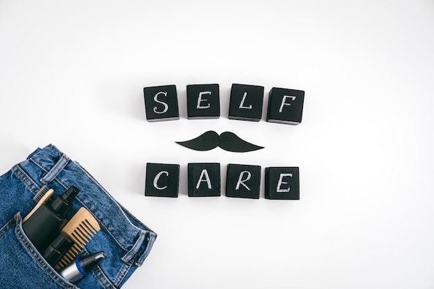 Men self care concept with blue denim jeans and set of male care products and devices and black