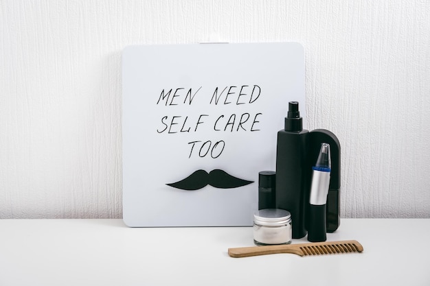 Men self care kit with male beauty care products and devices and letter board with text men need