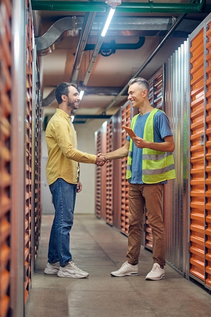 Men shaking hands to each other in warehouse