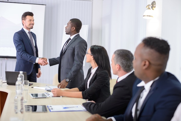 Men shaking hands at an office meeting.