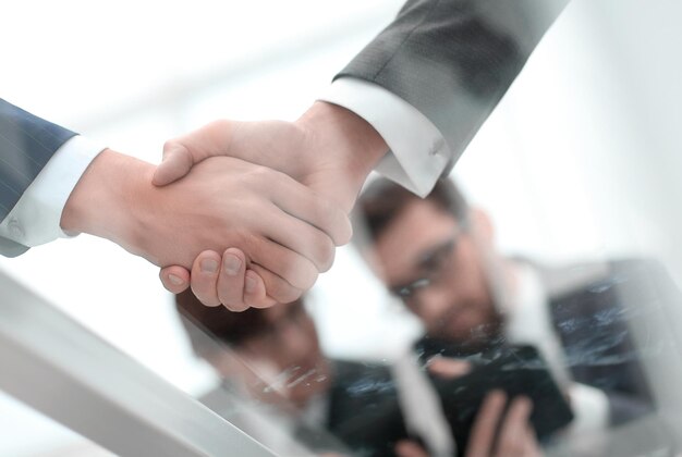Men shaking hands with smile at office with their coworkers