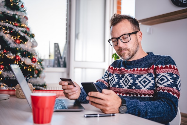 クリスマスの間にオンラインショッピングの男性