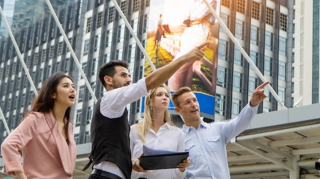 men showing something to colleague against building in city