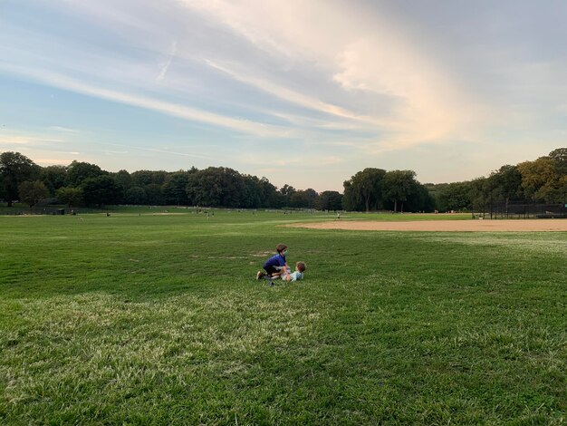 Photo men sitting on field against sky