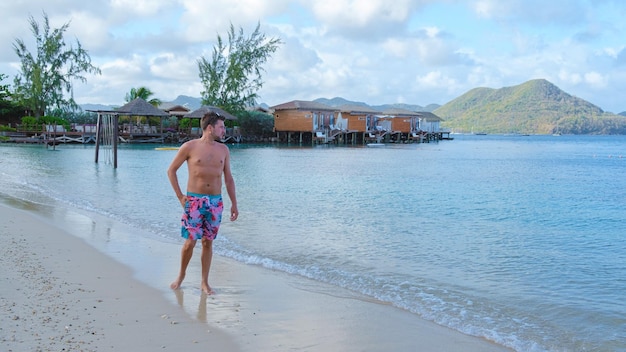 Men in swim short on the beach of the tropical island saint\
lucia or st lucia caribbean