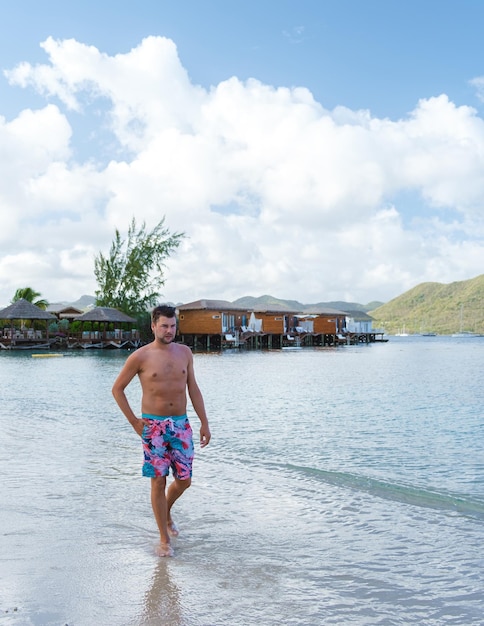 Men in swim short on the beach of the tropical island saint\
lucia or st lucia caribbean