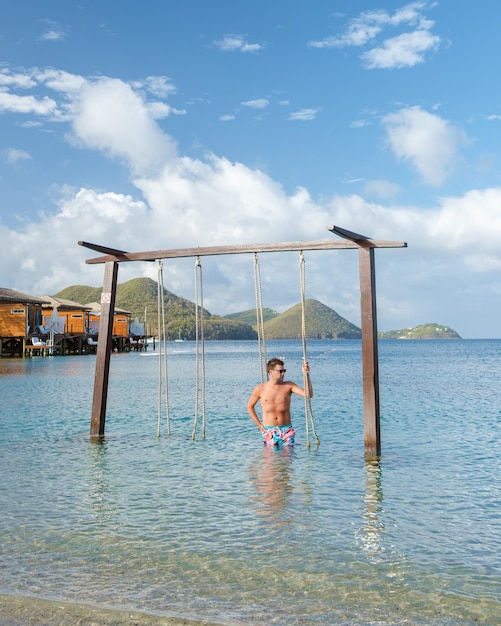 Men in a swing on the beach of the tropical island saint lucia\
or st lucia caribbean