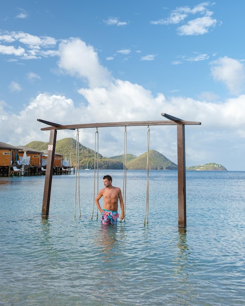 Men in a swing on the beach of the tropical island saint lucia\
or st lucia caribbean