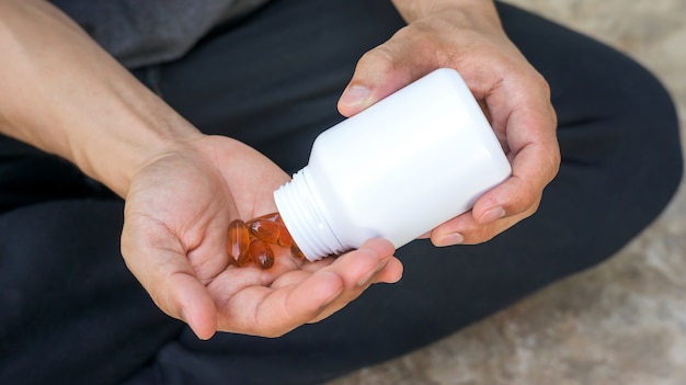 Men take a sunflowers oil capsule.