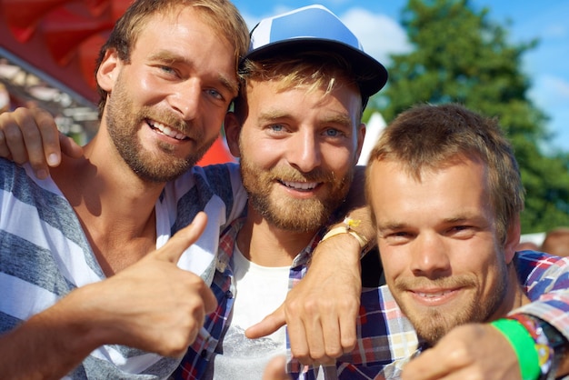 Photo men thumbs up and portrait at outdoor festival in nature excited and happy for bonding together friends face and reunion in summer on holiday adventure and yes approval at carnival in denmark