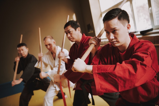 Men in training practice methods with sticks.