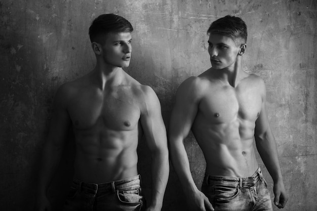 Uomini gemelli in posa con il torso forte e nudo